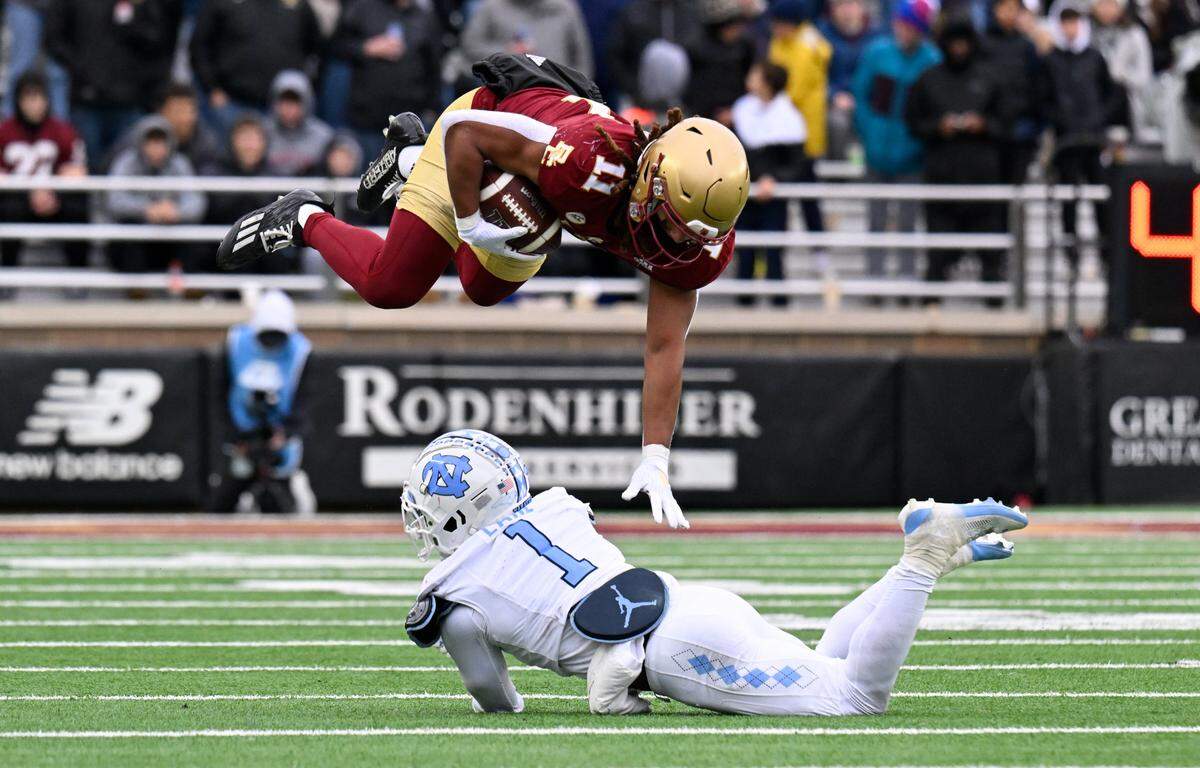 Boston College Eagles wide receiver Lewis Bond (11) leaps over North Carolina Tar Heels defensive back Antavious Lane (1) during the first half at Alumni Stadium.