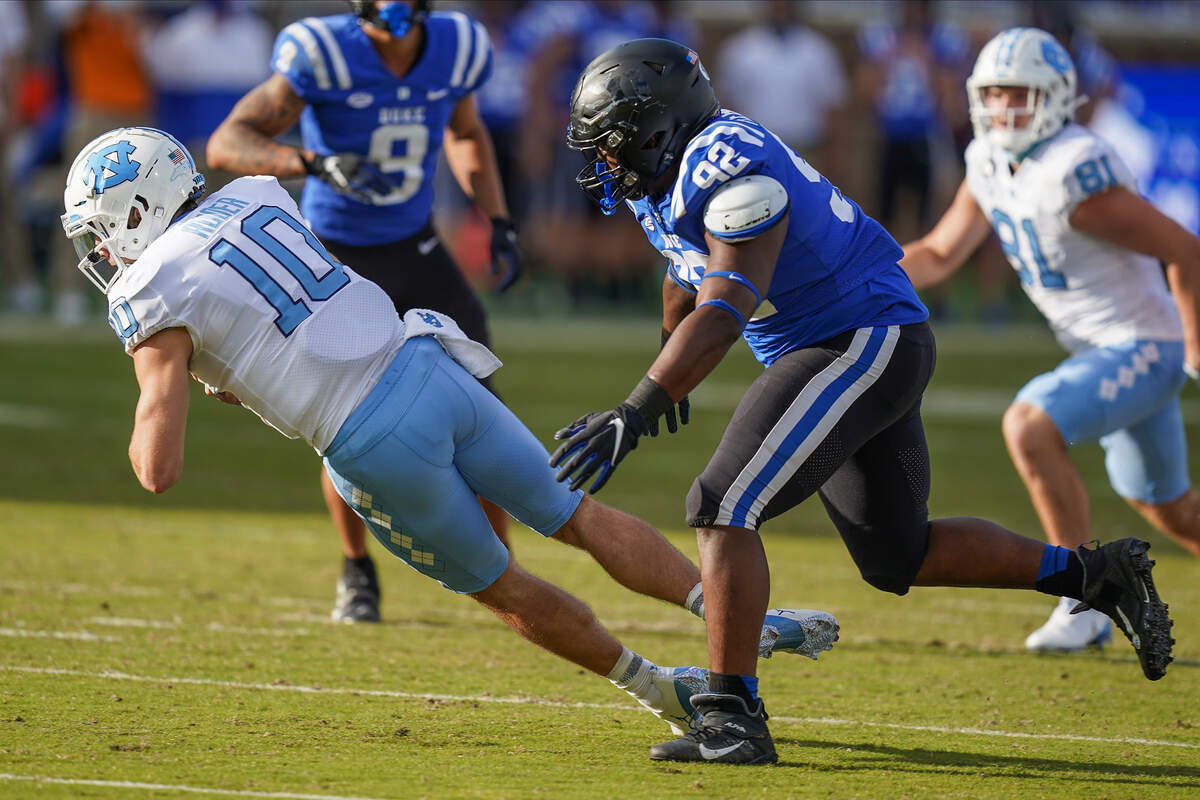 North Carolina Tar Heels quarterback Jace Ruder (10) dives for extra yardage while covered by Duke Blue Devils defensive tackle Aeneas Peebles (92) during the second half at Wallace Wade Stadium.