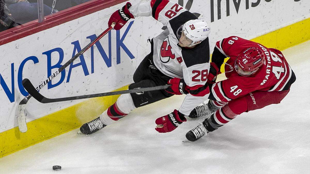 Carolina’s Hurricanes’ Jordan Martinook (48) battles for the puck with New Jersey’s Damon Severson (28) during the first period on Thursday, April 28, 2022 at PNC Arena in Raleigh, N.C.