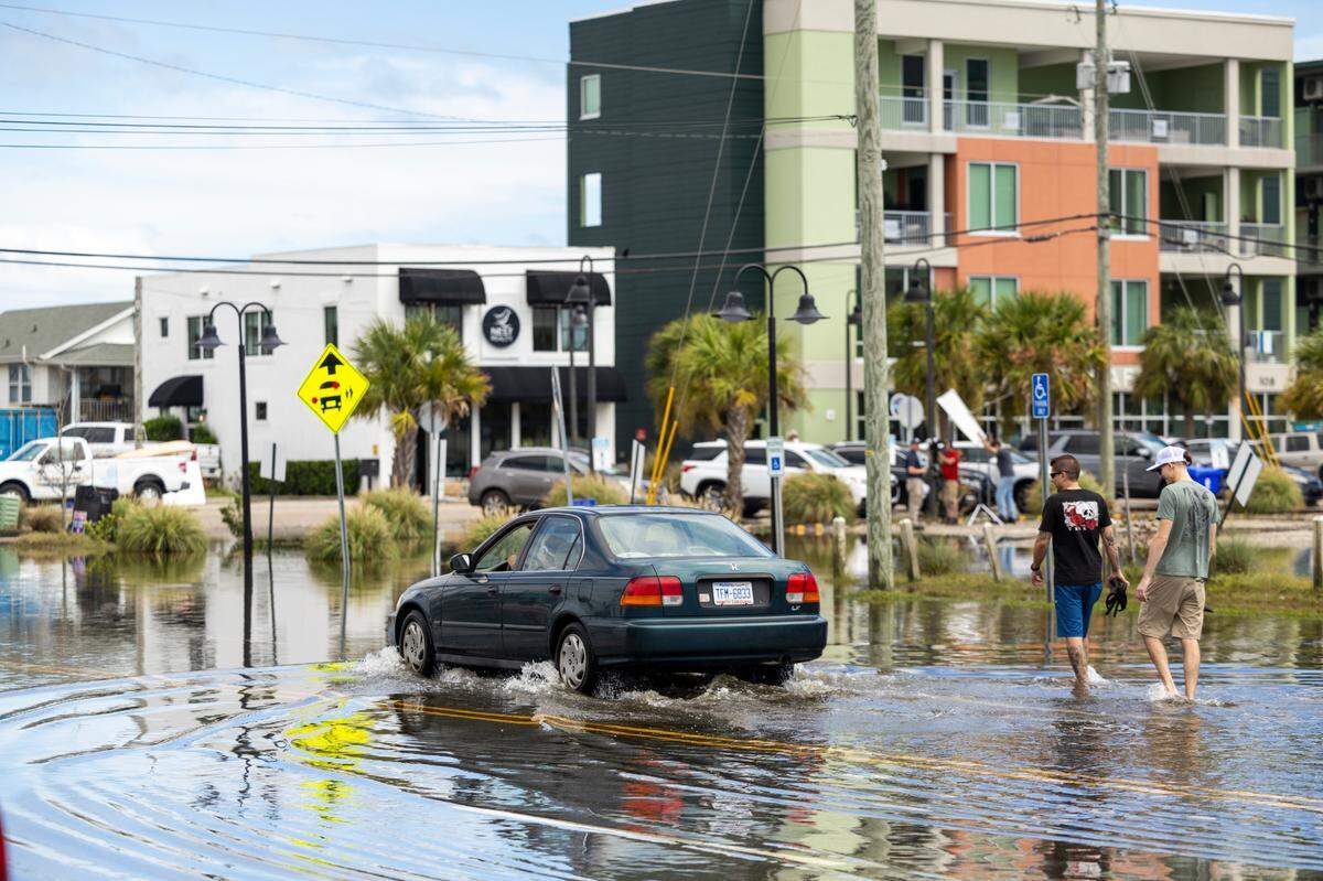 A motorist drives through floodwaters in Carolina Beach on Tuesday, Sept. 17, 2024 after an unnamed storm dropped as much as 18 inches of rain in southeastern North Carolina over a 72-hour period. Flood Levels in Carolina Beach rivaled that of Hurricane Floyd in 1999.