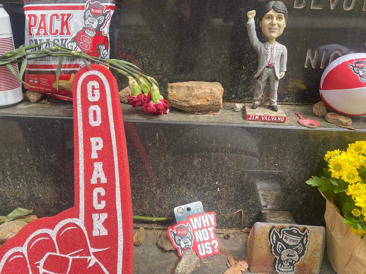 NC State fans deliver fresh gifts to Jim Valvano’s grave in Oakwood Cemetery.