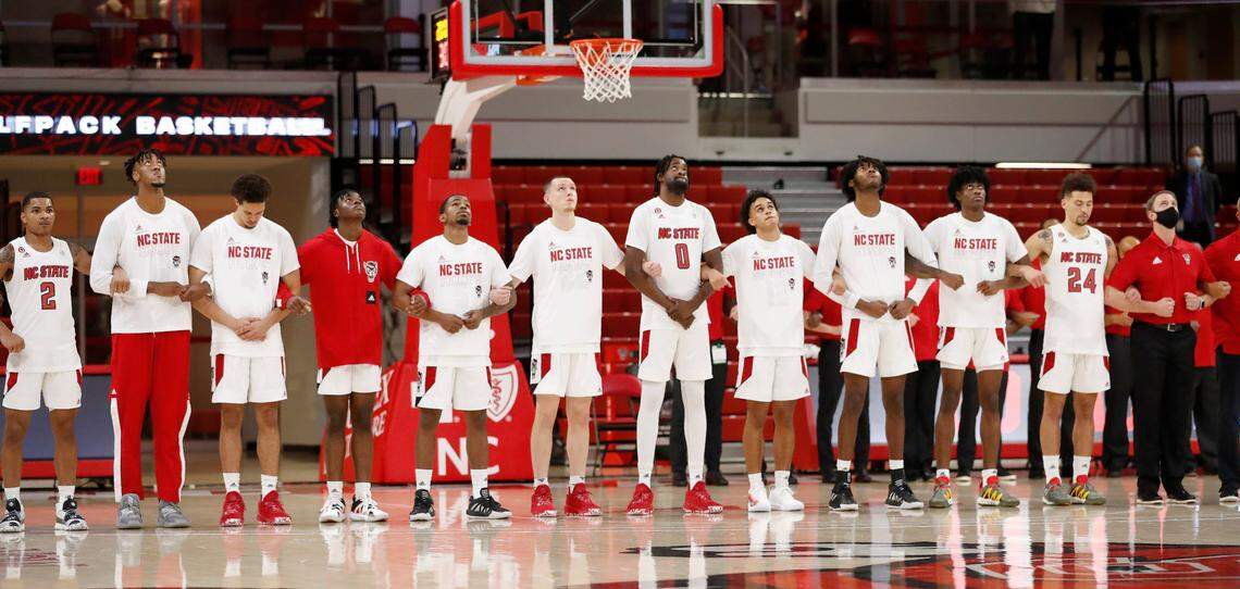 N.C. State players and coaches lock arms before the Wolfpack’s game against Charleston Southern in the Wolfpack Invitational at Reynolds Coliseum in Raleigh, N.C., Wednesday, Nov. 25, 2020.