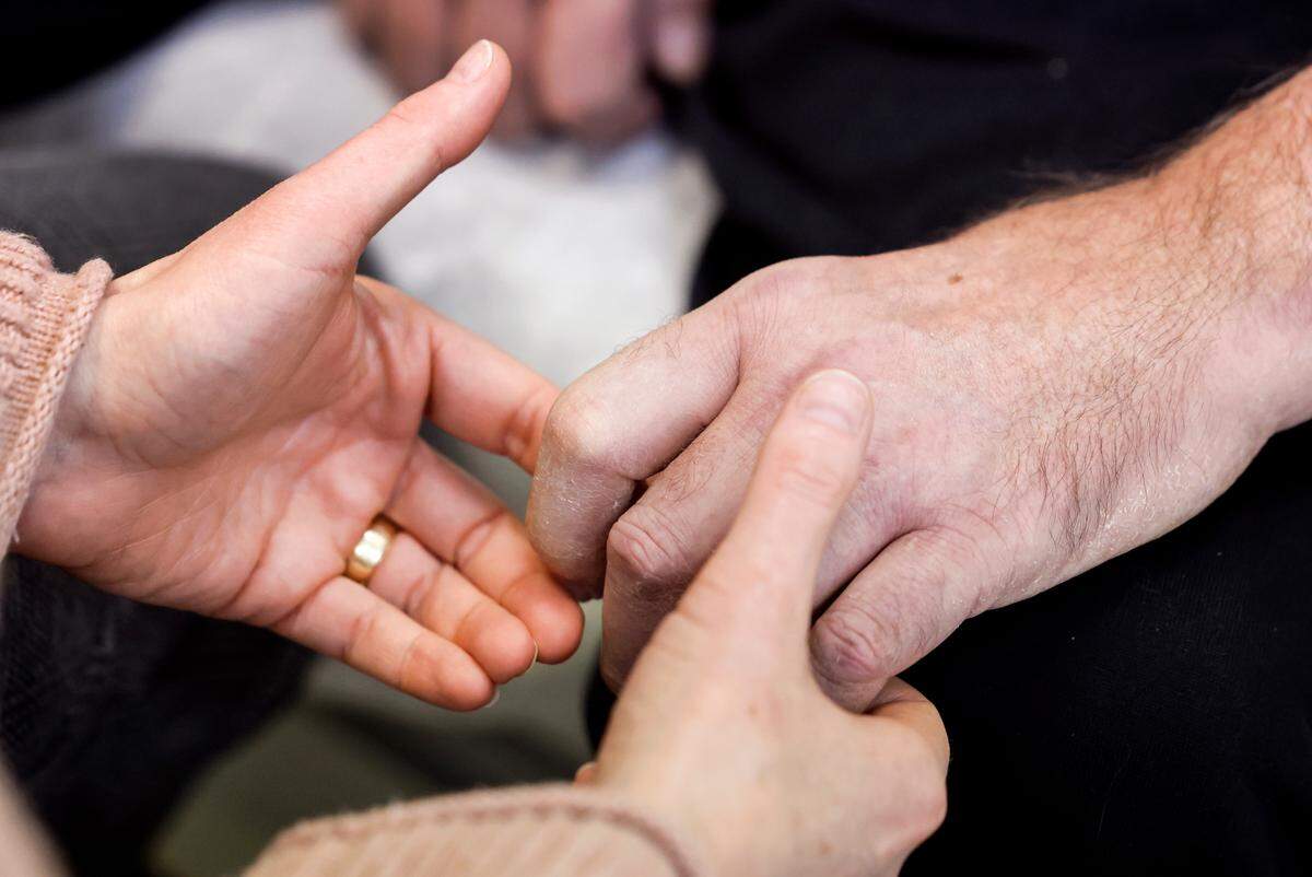 Occupational Therapist Jessica Backhus works with Roy Woodlief on trying to straighten his fingers during Woodlief’s appointment at the Duke ALS Clinic in Durham, N.C., Tuesday, Jan. 21, 2025. Woodlief has been diagnosed with amyotrophic lateral sclerosis (ALS), forcing him to retire from the Wake County Sheriff’s Office. The fatal disease causes muscle weakness, making it difficult to walk, eat and eventually breathe.