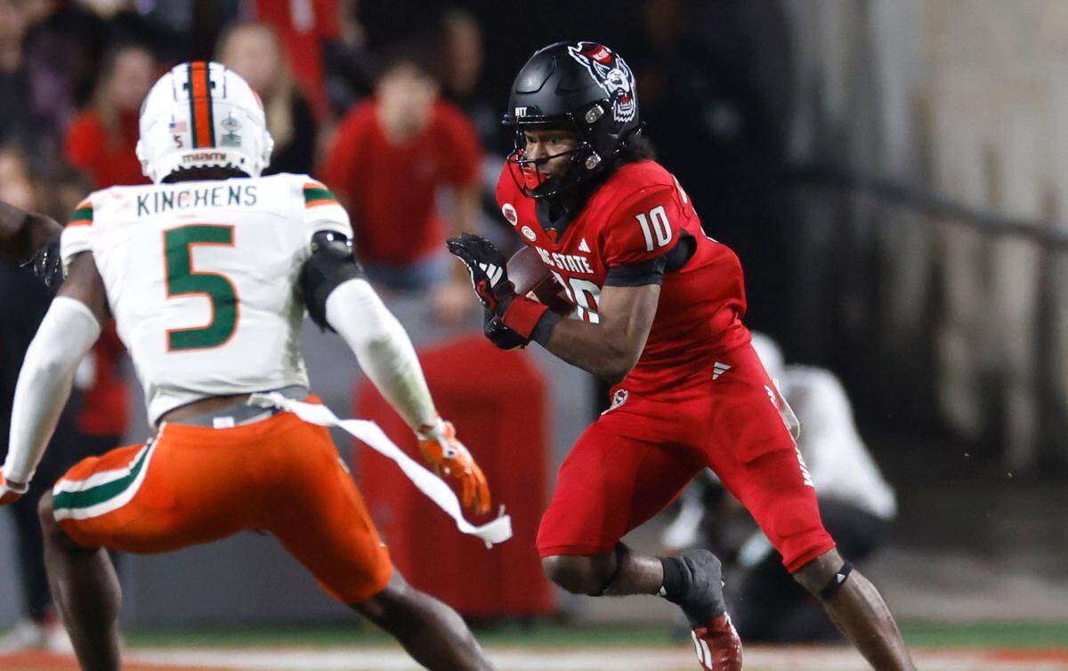 N.C. State’s KC Concepcion (10) gains yards as Miami safety Kamren Kinchens (5) closes in during the first half of N.C. State’s game against Miami at Carter-Finley Stadium in Raleigh, N.C., Saturday, Nov. 4, 2023.