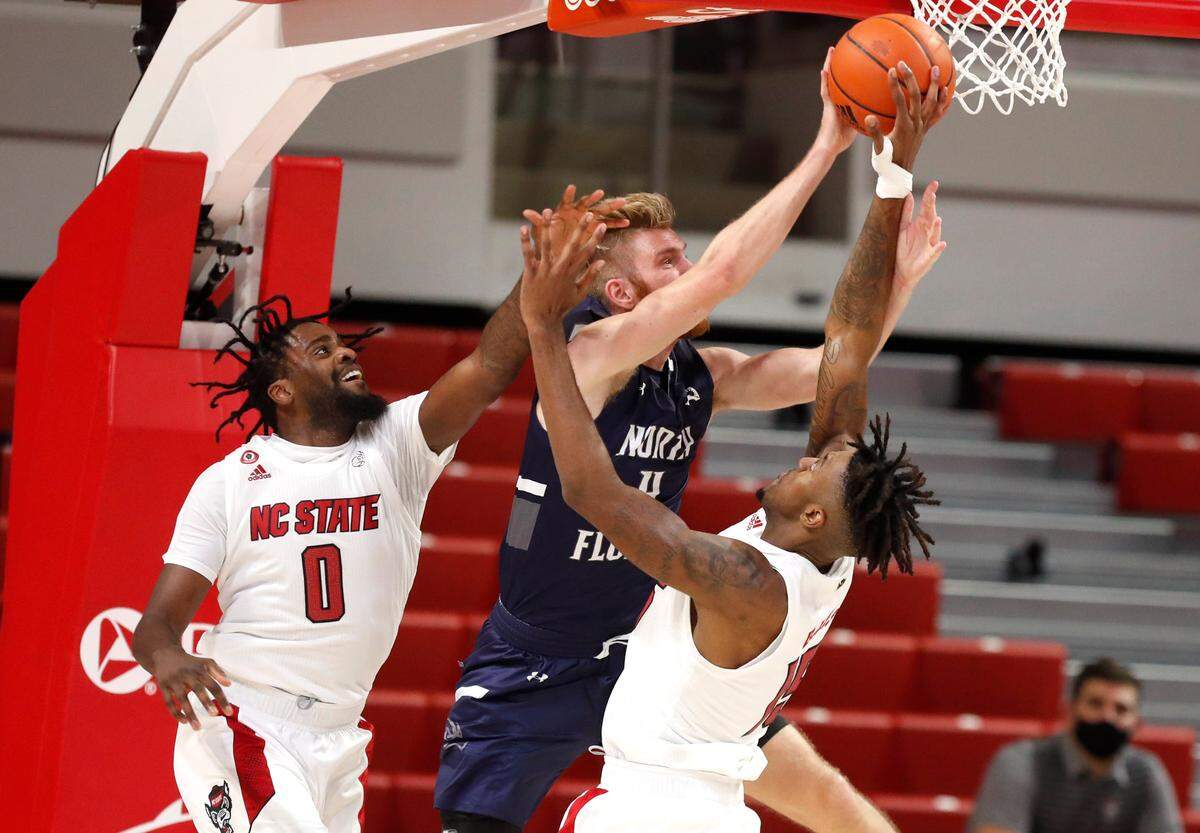 N.C. State’s D.J. Funderburk (0) and Manny Bates (15) defend North Florida’s Josh Endicott (4) during the first half of N.C. State’s game against North Florida in the Mako Medical Wolfpack Invitational at Reynolds Coliseum in Raleigh, N.C., Friday, Nov. 27, 2020.