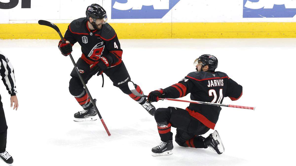 Carolina's Shayne Gostisbehere (4) celebrates with Seth Jarvis (24) after he scored in overtime of the Hurricanes’ 4-3 victory over the Golden Knights in the second game of the Stanley Cup Final at the Lenovo Center in Raleigh, North Carolina, on Thursday, June 4, 2026.