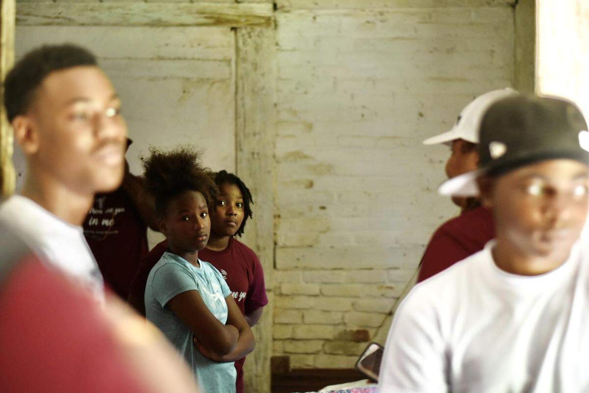 Brighe Fletcher and Nakayla Brickhouse (foreground) listen to a historic interpreter talk about life in Horton Grove, the original quarters where enslaved people lived in Stagville, on Saturday, June 18, 2022.