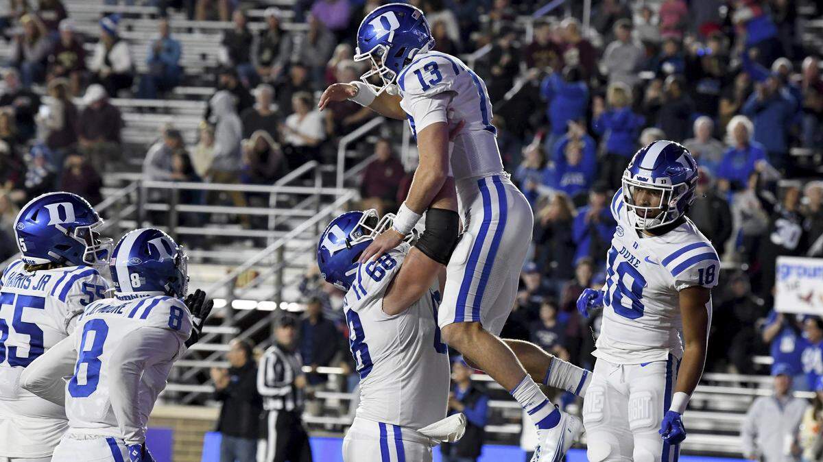 Duke quarterback Riley Leonard (13) is lifted by center Jack Burns after scoring a touchdown during the first half of an NCAA college football game against Boston College, Friday, Nov. 4, 2022 in Boston. (AP Photo/Mark Stockwell)