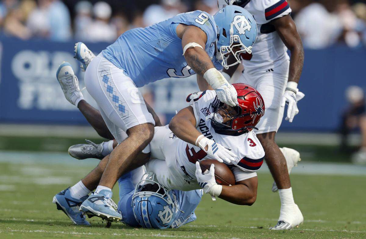 North Carolina’s Marcus Allen (29) and Melkart Abou-Jaoude (9) tackle Richmond running back Aziz Foster-Powell (3) during the first half of UNC’s game against Richmond at Kenan Stadium in Chapel Hill, N.C., Saturday, Sept. 13, 2025.