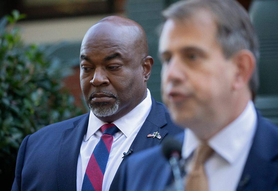 North Carolina Lt. Gov. Mark Robinson, left, the Republican nominee for governor, listens during a press conference on Tuesday, Oct. 15, 2024, in Raleigh, N.C.