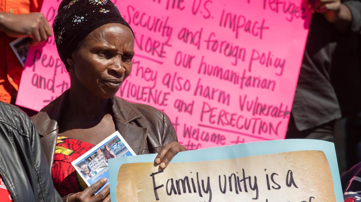 In 2019, Sarah Mukaruguiza, a refugee from the Democratic Republic of the Congo, holds a sign during a press conference organized by Church World Service in Durham, North Carolina, to call attention to the then-Trump administration’s reduction in funding for the U.S. Refugee Resettlement Program.