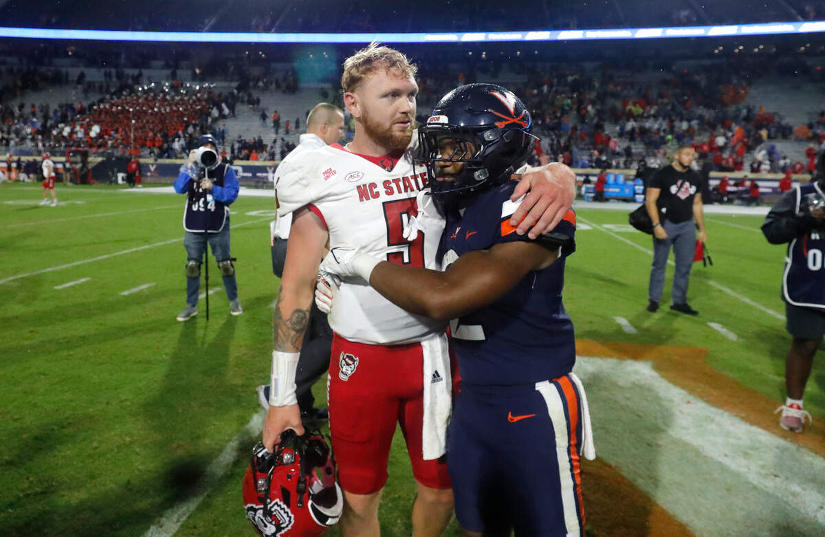 N.C. State quarterback Brennan Armstrong (5) talks with Virginia running back Perris Jones (2) after the Wolfpack’s 24-21 victory over Virginia at Scott Stadium in Charlottesville, Va., Friday, Sept. 22, 2023.
