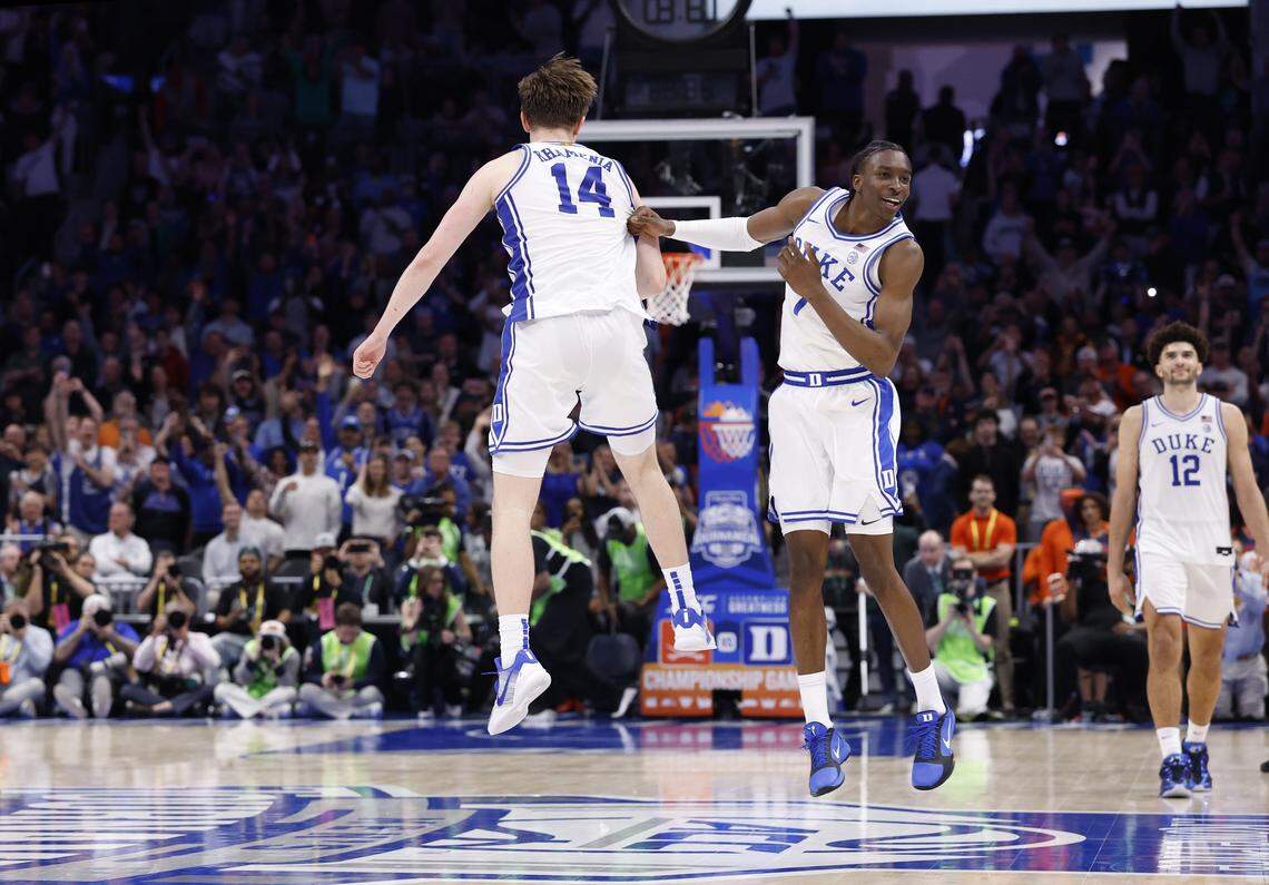 Duke’s Nikolas Khamenia (14) and Dame Sarr (7) celebrate as time runs out in Duke’s 74-70 victory over Virginia in the finals of the 2026 ACC Men’s Basketball Tournament at the Spectrum Center in Charlotte, N.C., Saturday, March 14, 2026.