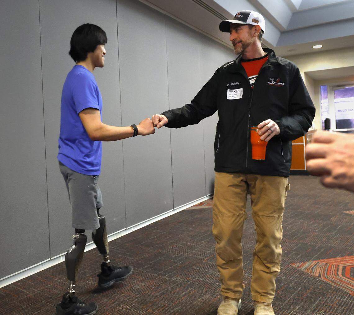 Kayden Beasley fist-bumps Brian Jacoby after participating in a press conference at the Lenovo Center on Feb. 24, 2026. Beasley is a member of the U.S. National Sled Hockey Team who are competing in the 2026 Paralympic Winter Games in Italy.