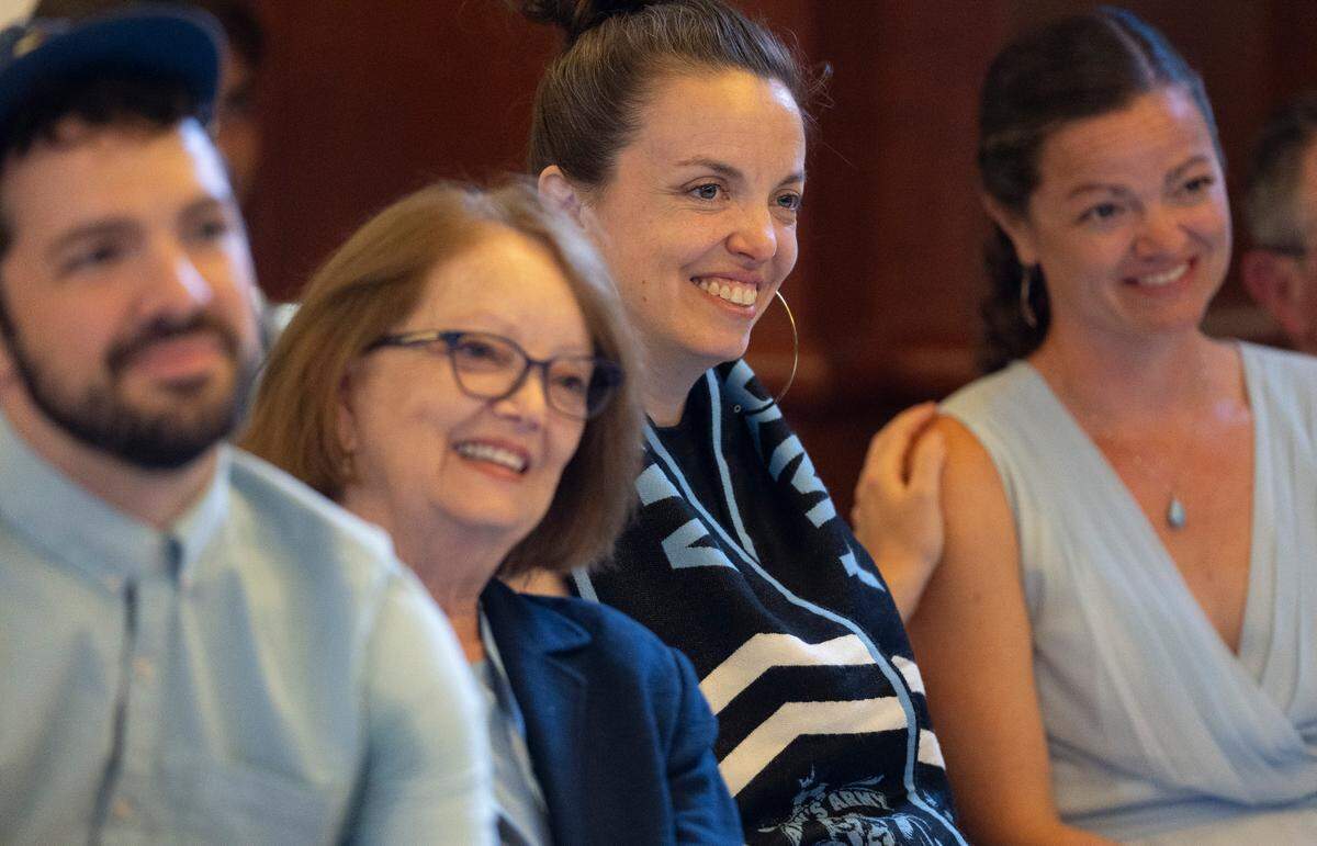 Anson Dorrance’s family members from left, son Donovan Dorrance, wife, M’Liss Dorrance, daughters Michelle Dorrance and Natalie Dorrance Harris listen as coach Anson Dorrance delivers remarks during his retirement press conference on Monday, August 12, 2024 at the Smith Center in Chapel Hill, N.C.