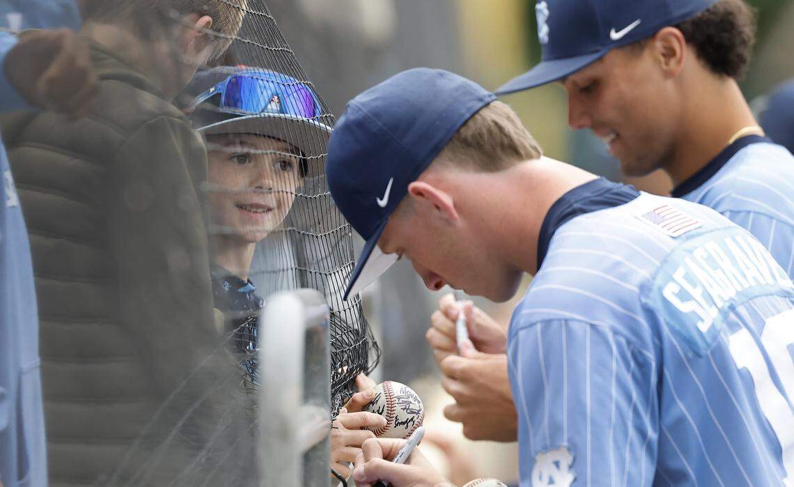 Seven-year-old Bennett Irvin of Durham watches as North Carolina's Camron Seagraves (19) and Boston Flannery (42) sign autographs before their game with Georgia Tech at Boshamer Stadium in Chapel Hill, N.C., Sunday, April 19, 2026.