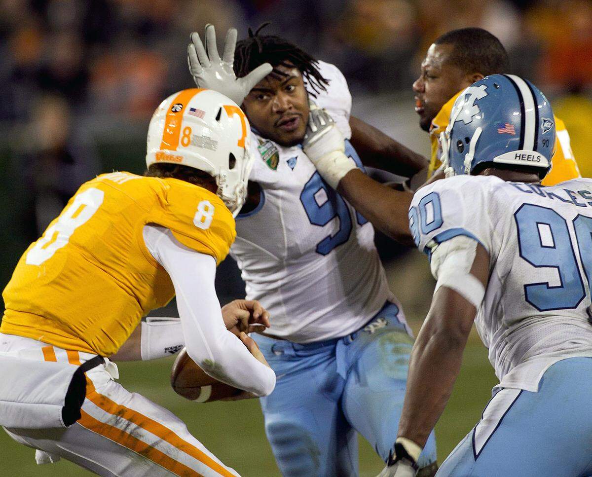 UNC’s Donte Paige-Moss goes after Tennessee quarterback Tyler Bray (8) despite losing his helmet on the play. Robert Willett - rwillett@newsobserver.com