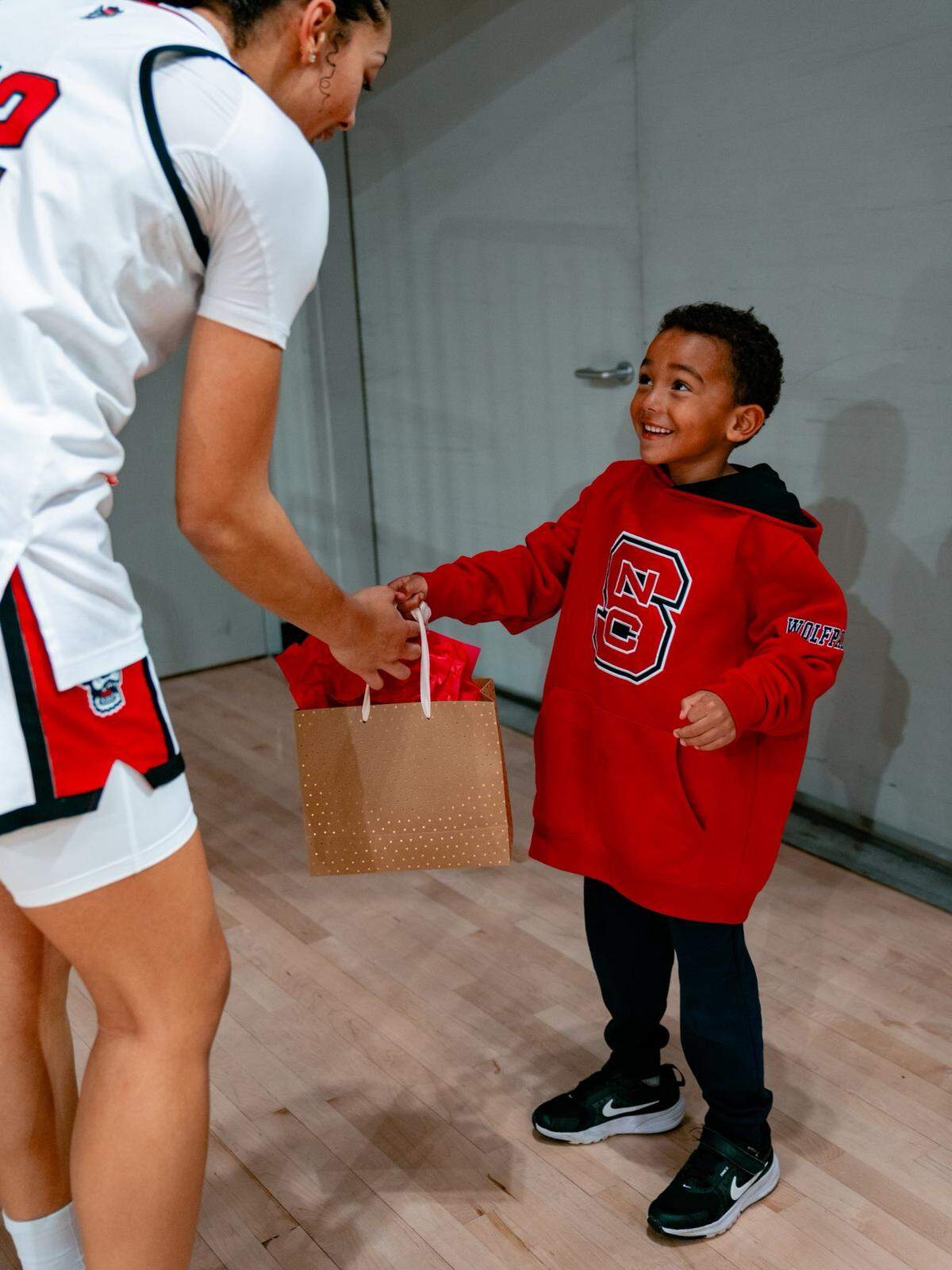 N.C. State forward Khamil Pierre accepts a gift from fan Braylon Collins after a game at Reynolds Coliseum in Raleigh, North Carolina.