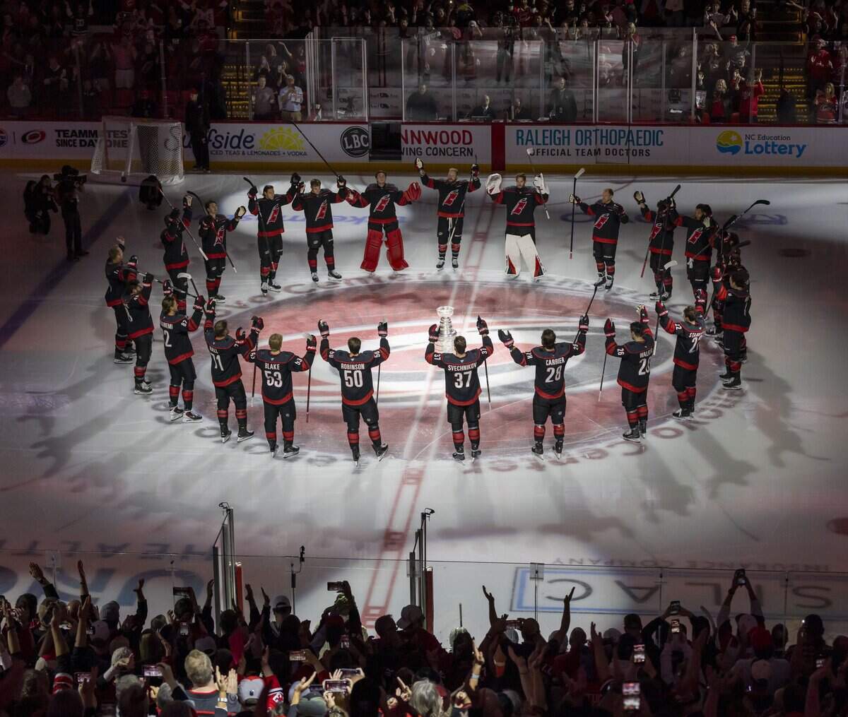 The Carolina Hurricanes surround the Stanley Cup at center ice, as they celebrate their 2026 Championship ahead of their opening night game against Florida, on Tuesday, Sept. 29, 2026, at Lenovo Center in Raleigh, N.C.