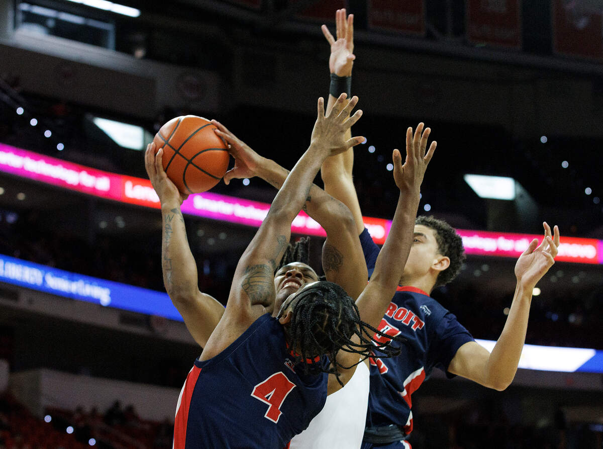 N.C. State’s MJ Rice drives between Detroit’s Marcus Tankersley and Michael Oaks during the first half of the Wolfpack’s game on Saturday, Dec. 23, 2023, at PNC Arena in Raleigh, N.C.