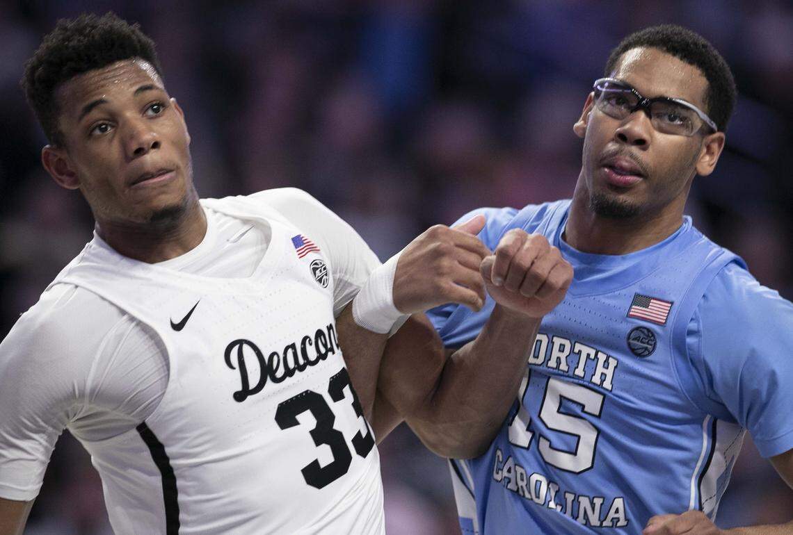 North Carolina’s Garrison Brooks (15) gets tangled with Wake Forest’s Ody Oguama (33) as they battle for rebound position in the first half on Tuesday, February 11, 2020 at Lawrence Joel Coliseum in Winston-Salem, N.C. Brooks wore a pair of sport glasses to protect his injured eye.