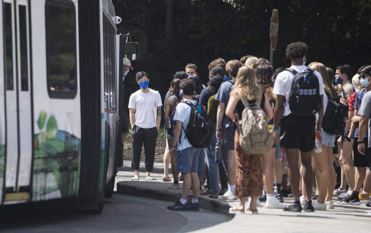 Duke University students wait to board a bus on the Durham, N.C. school's west campus on Tuesday, Aug. 31, 2021.