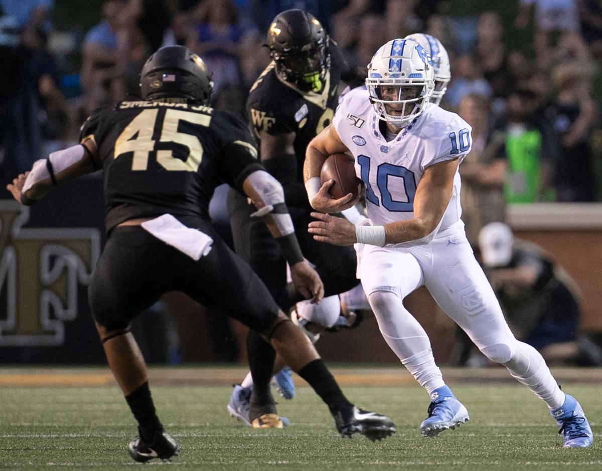 North Carolina quarterback Jace Ruder (10) rushes for seven yard in the second quarter against Wake Forest’s Ryan Smenda Jr. (45) on Friday, September 13, 2019 at BB&T Field in Winston-Salem, N.C.