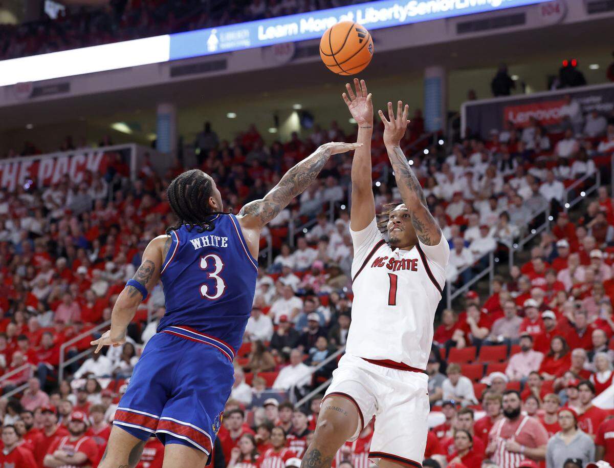 N.C. State’s Darrion Williams shoots over Kansas’ Tre White during the first half of the Wolfpack’s game on Saturday, Dec. 13, 2025, at Lenovo Center in Raleigh, North Carolina.