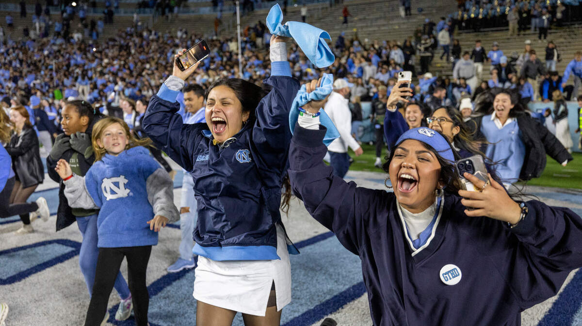 North Carolina fans storm the field following their 47-45 double overtime victory against Duke on Saturday, Nov. 11, 2023 at Kenan Stadium in Chapel Hill, N.C. 