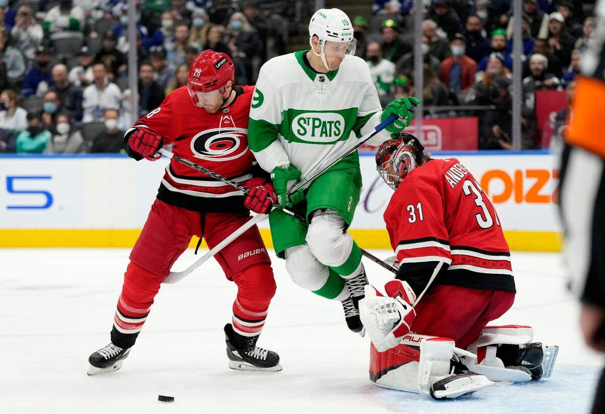 Toronto Maple Leafs center Jason Spezza (19) jumps out of the way of an incoming puck as Carolina Hurricanes goaltender Frederik Andersen (31) and teammate Ian Cole (28) defend during the second period of an NHL hockey game Thursday, March 17, 2022, in Toronto. (Frank Gunn/The Canadian Press via AP)