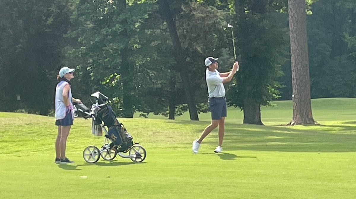 Chesson Hadley, with wife/caddie Amanda watching, hits his approach shot on the 17th hole at Duke University Golf Club during U.S. Open final qualifying on Monday. Hadley made birdie on 17 to finish 4-under-par and earn a spot in Pinehurst in two weeks.