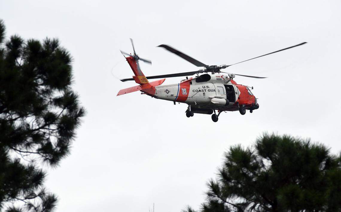 A Coast Guard helicopter files low and slow over homes near Hampstead, N.C. Sunday, September 16, 2018 looking for flood victims as Tropical Storm Florence continued to pelt the area with rain and wind.