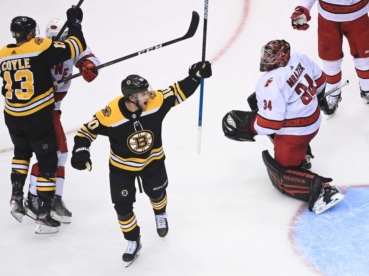 Boston Bruins left wing Anders Bjork (10) celebrates his teammates goal past Carolina Hurricanes goaltender Petr Mrazek (34) during the second period of an NHL hockey Eastern Conference Stanley Cup playoff game in Toronto, Wednesday, Aug. 12, 2020.