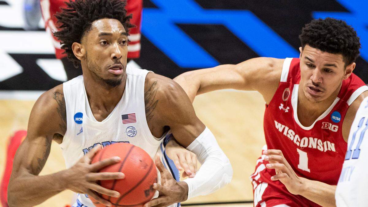 North Carolina’s Leaky Black, left, drives in against Wisconsin’s Jonathan Davis (1) during the first half of a first-round game in the NCAA men’s college basketball tournament, Friday, March 19, 2021, at Mackey Arena in West Lafayette, Ind. 
