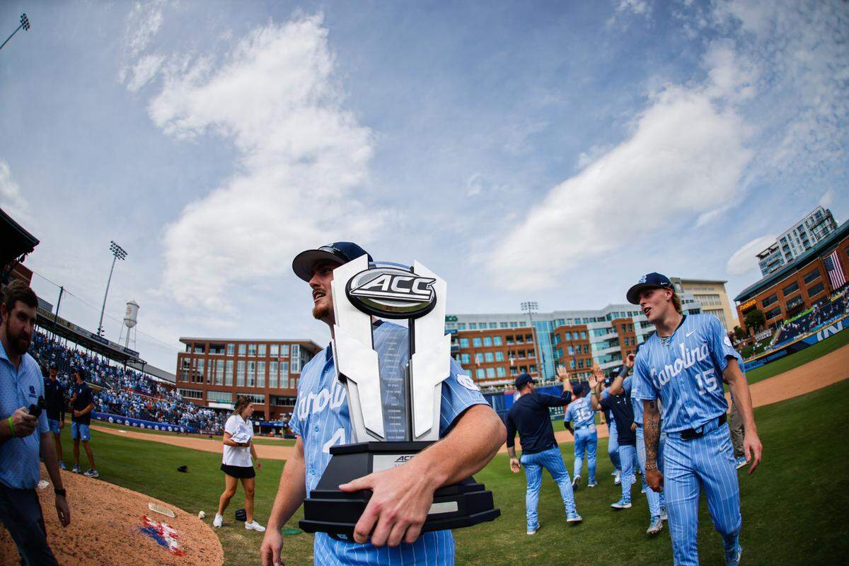 UNC first baseman Hunter Stokely carries the ACC trophy after the Tar Heels win the ACC baseball championship against Clemson, 14-4, on Sunday, May 25, 2025, at Durham Bulls Athletic Park in Durham, N.C.