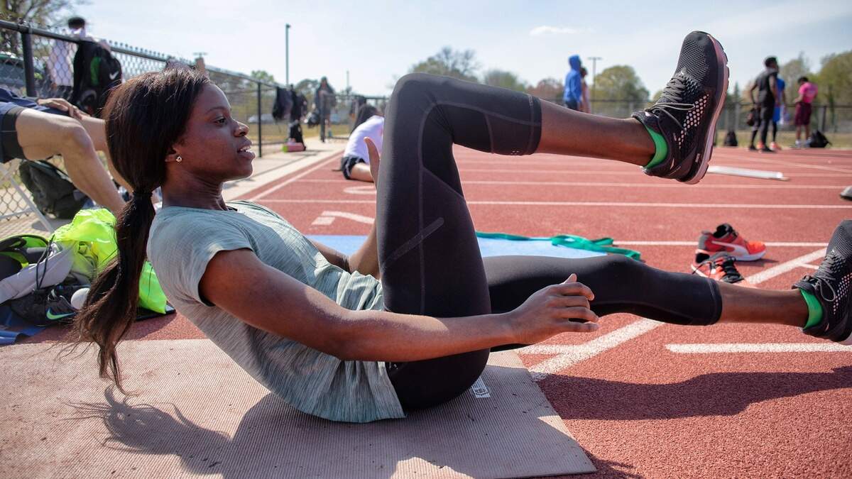 Tia Adana-Belle stretches before a workout at St. Augustine’s University in Raleigh Thursday, April 4, 2019. Belle hopes to return to the Olympics in the women’s 400 meter hurdles.