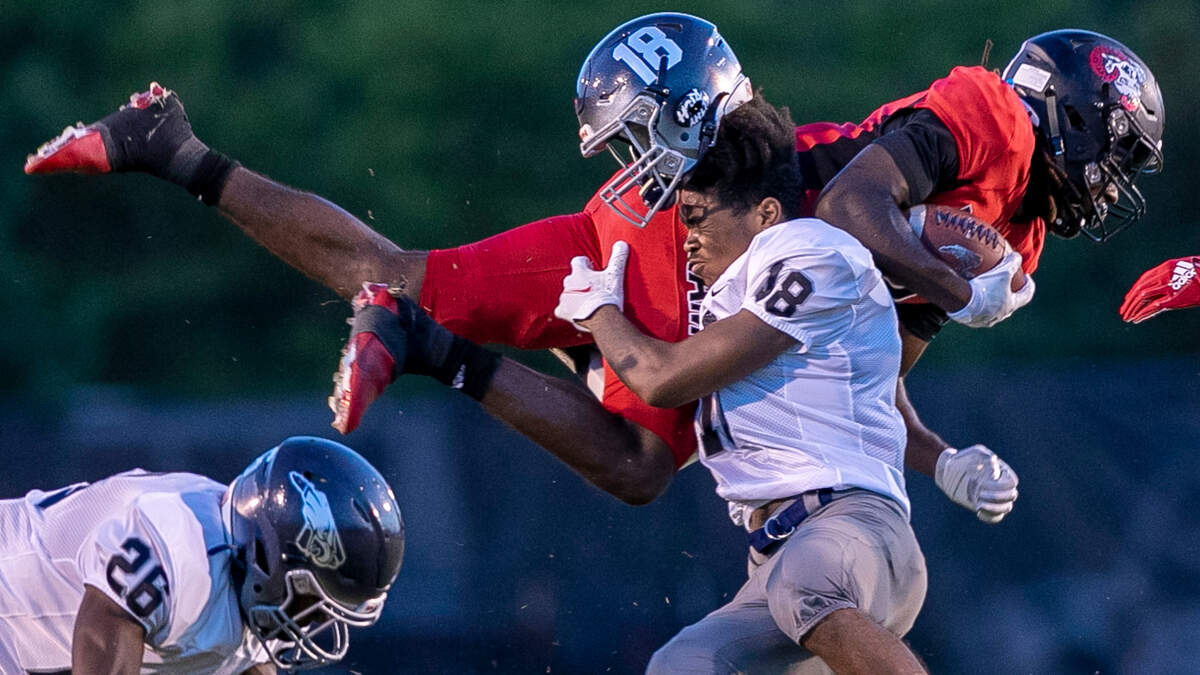 East Forsyth’s K.J. Wright (18) loses his helmet as he stops Rolesville’s Rory Jones (8) in the second quarter on Friday, August 26. 2022 at Roseville High School in Rolesville, N.C.