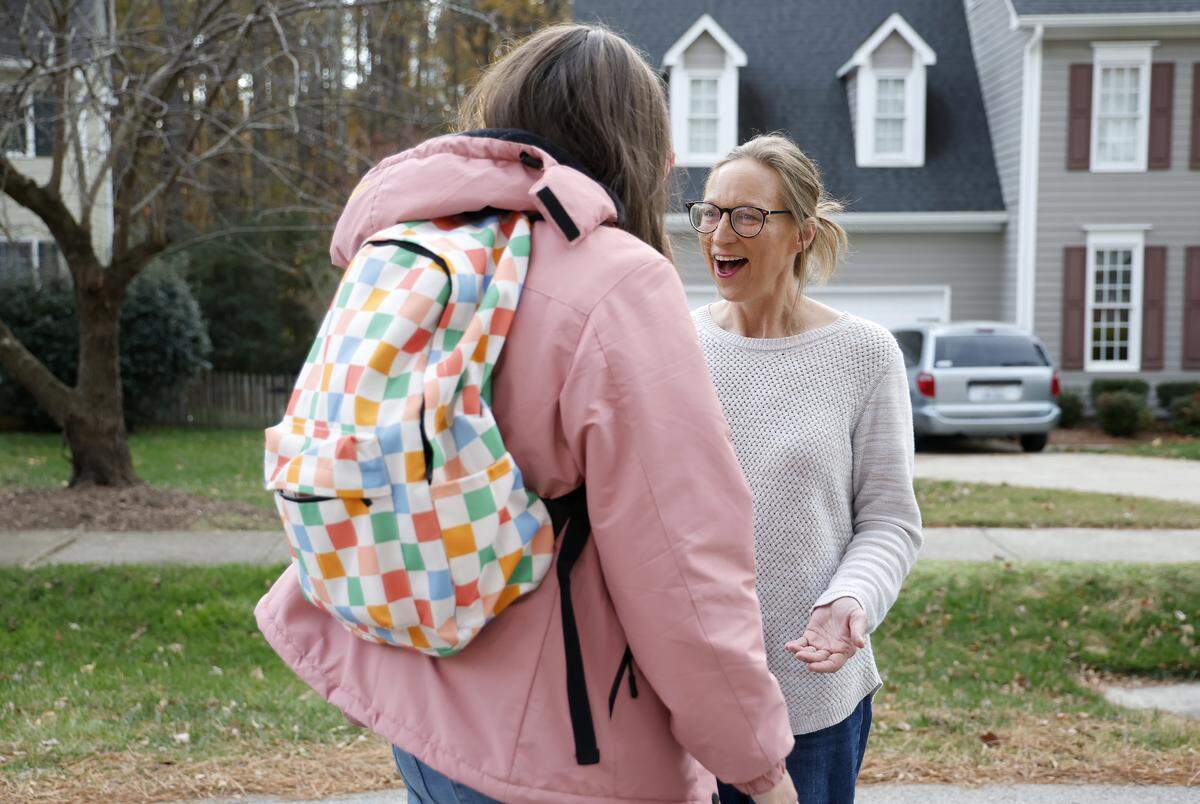 Lexi greets Krista Caraway after arriving home on a school bus.