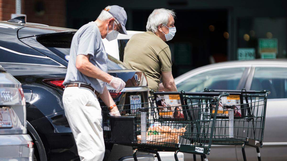 Customers of the Harris Teeter near University Mall in Chapel Hill unload their groceries in April while wearing masks and gloves. The company said on its website Thursday it will require customers to wear face coverings in all stores beginning July 22.
