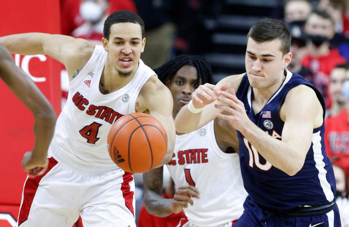 N.C. State’s Jericole Hellems (4) pulls in the rebound from Virginia’s Taine Murray (10) during the second half of N.C. State’s 77-63 victory over Virginia at PNC Arena in Raleigh, N.C., Saturday, Jan. 22, 2022.
