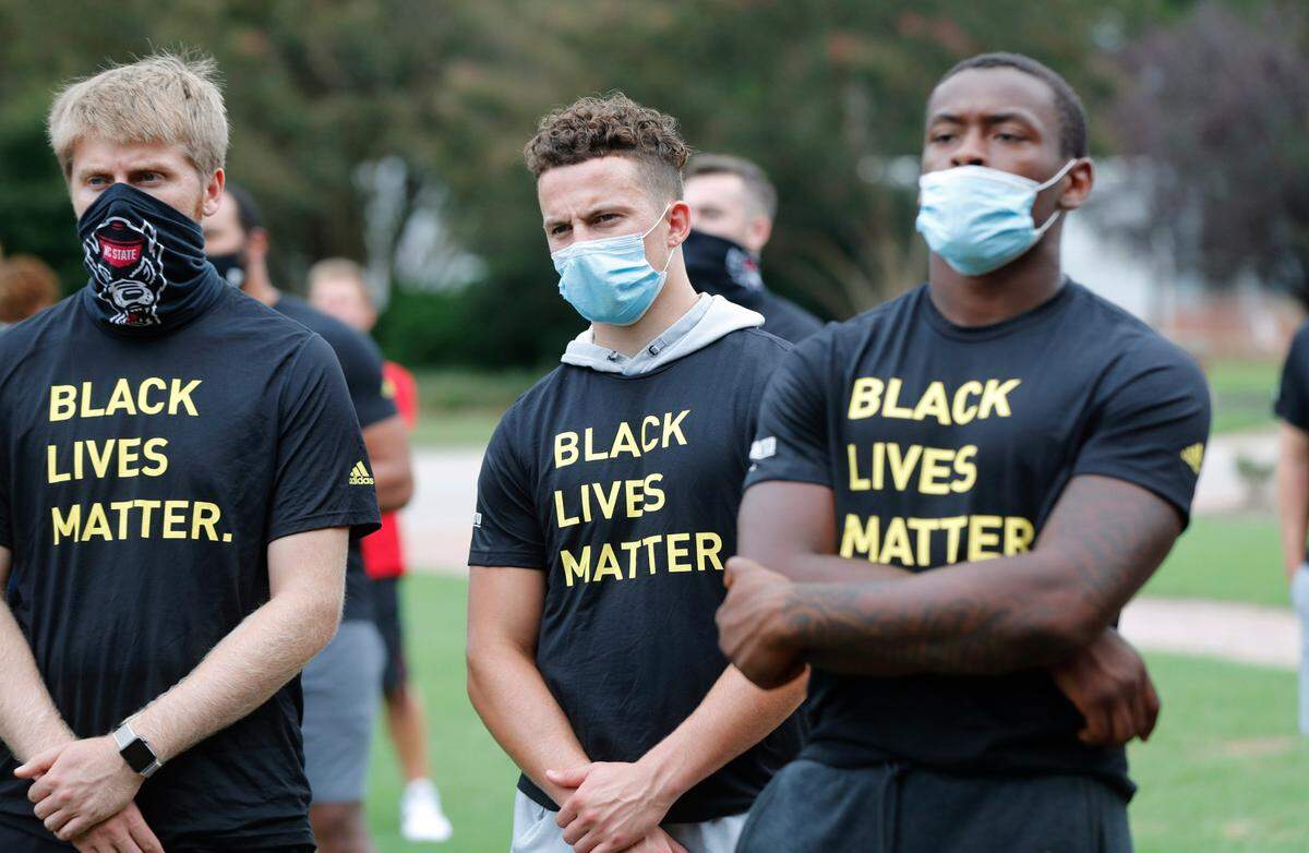 N.C. State athletes, coaches and staff listen to the speakers during a #PackUnited peaceful protest against racial and social injustice outside Holladay Hall on the campus of N.C. State Saturday, Sept. 12, 2020.