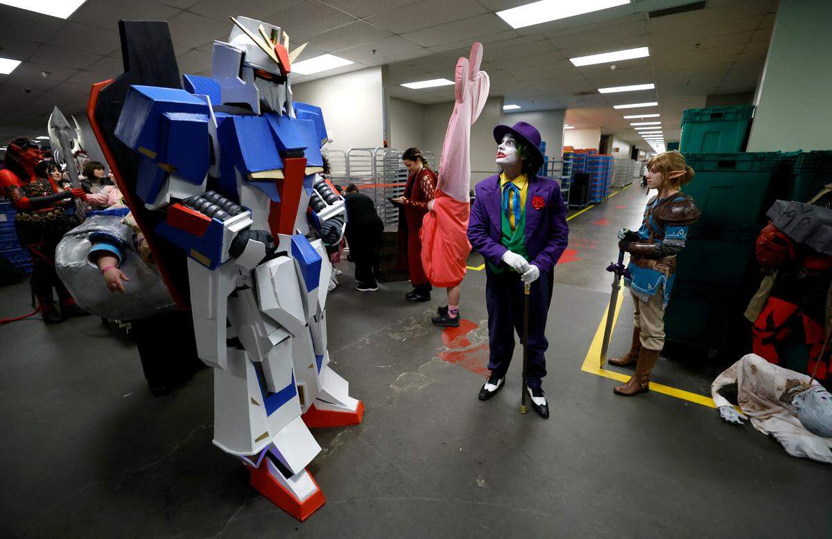 Noah Skotzko from Davidson, left, walks backstage before the costume competition at GalaxyCon Raleigh at the Raleigh Convention Center Saturday, July 27, 2024. Skotzko is dressed as Zeta Gundam from Mobile Suit Zeta Gundam.