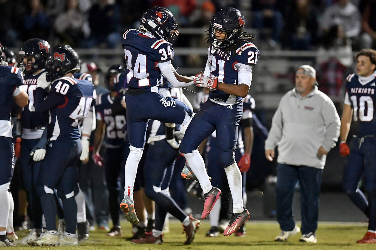 Apex Friendship's Bryant Jerome McLean (21) and David Benzinger (34) celebrate at the end of the first half for being tied with Rolesville. The Apex Friendship Patriots and the Rolesville Rams met in  the second round of the  NCHSAA 8A Playoff game in Apex, N.C. on November 14, 2025. Rolesville wins 14-7 in overtime.