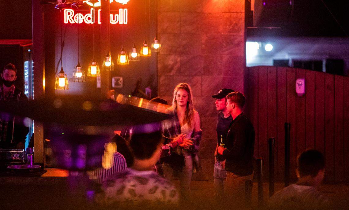 Patrons socialize at a bar in the Glenwood South bar and restaurant district in Raleigh Wednesday night, Nov. 25, 2020.