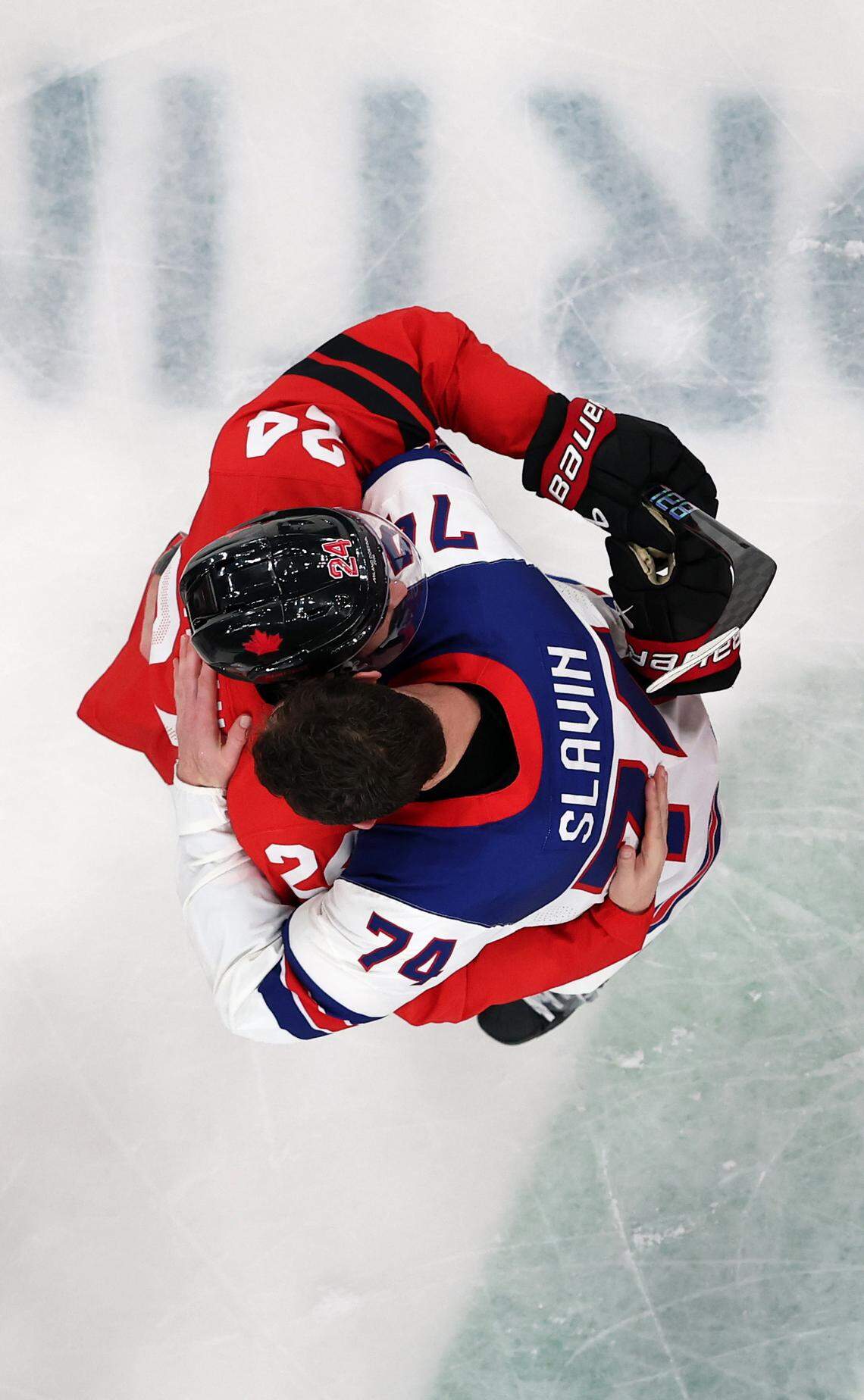 Jaccob Slavin (74) of Team United States embraces Seth Jarvis (24) Team Canada after the gold medal game of the Milano Cortina 2026 Winter Olympic games at Milano Santagiulia Ice Hockey Arena on Feb. 22, 2026.