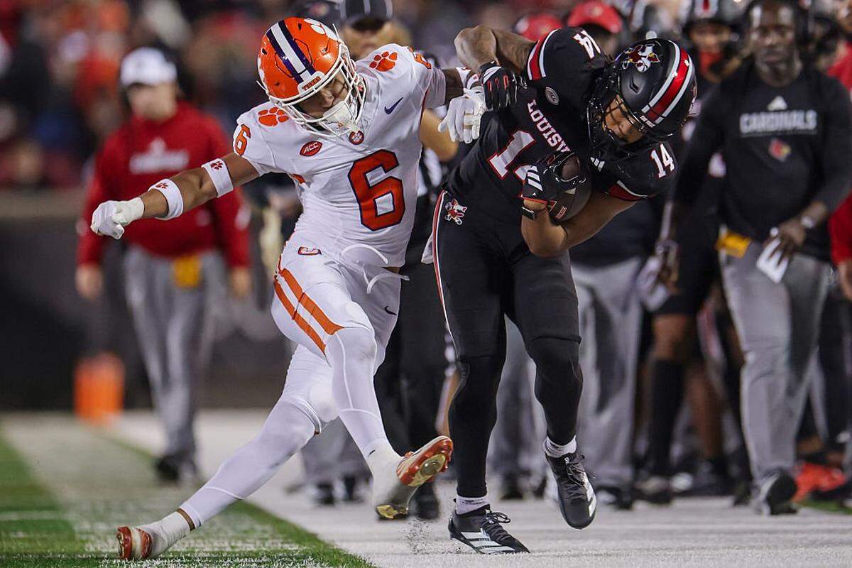 Ricardo Jones (6) of the Clemson Tigers knocks Kris Hughes (14) of the Louisville Cardinals out of bounds during the second half of the NCAA football game between the Louisville Cardinals and the Clemson Tigers at L&N Federal Credit Union Stadium on Nov. 14, 2025 in Louisville, Kentucky.