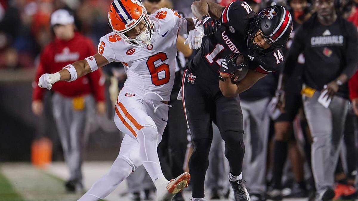 LOUISVILLE, KENTUCKY - NOVEMBER 14: Ricardo Jones #6 of the Clemson Tigers knocks Kris Hughes #14 of the Louisville Cardinals out of bounds during the second half of the NCAA football game between the Louisville Cardinals and the Clemson Tigers at L&N Federal Credit Union Stadium on November 14, 2025 in Louisville, Kentucky. (Photo by Michael Hickey/Getty Images)