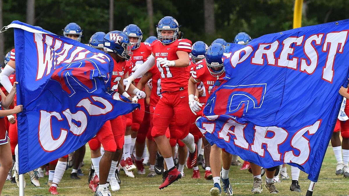 Wake Forest’s Logan Cooper (41) and his team burst through the banner and run onto the field .The Wake Forest Cougars and the Southern Durham Spartans met in a football game in Wake Forest, N.C. on August 19, 2022.