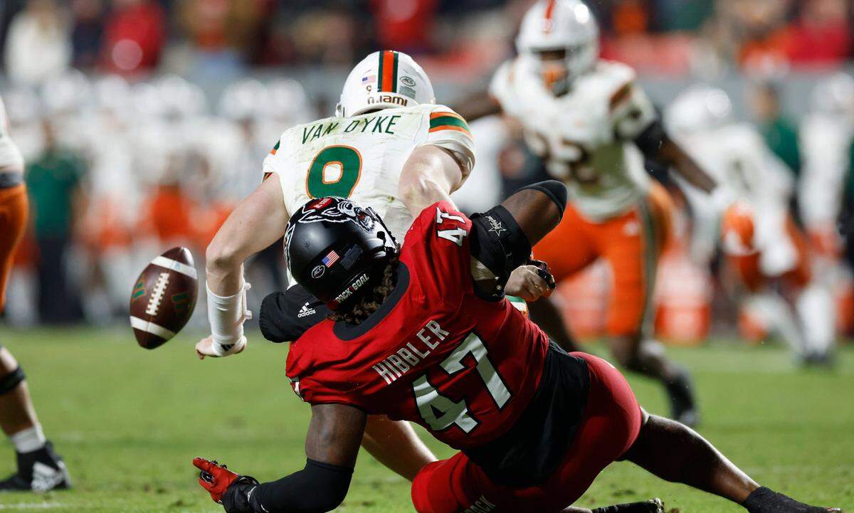 N.C. State defensive lineman Red Hibbler (47) sacks Miami quarterback Tyler Van Dyke (9) forcing a fumble during the first half of N.C. State’s game against Miami at Carter-Finley Stadium in Raleigh, N.C., Saturday, Nov. 4, 2023.