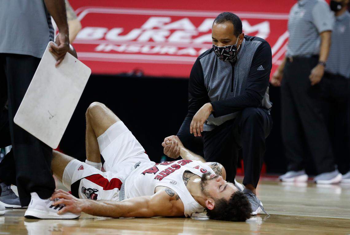 N.C. State head coach Kevin Keatts comforts Devon Daniels (24) after Daniels was injured during the second half of N.C. State’s 72-67 victory over Wake Forest at PNC Arena in Raleigh, N.C., Wednesday, January 27, 2021.